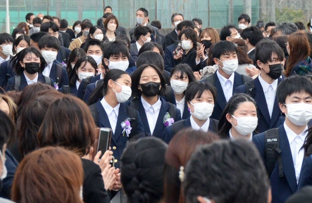 今年３月に行われた三田市立けやき台中学校の卒業式で、保護者らに見守られながら花道を歩く卒業生＝三田市けやき台２