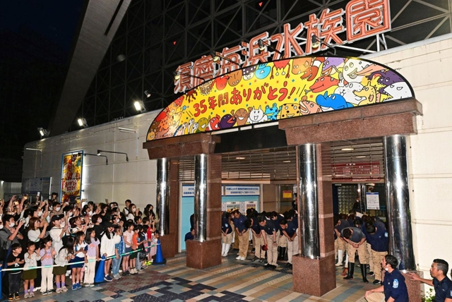 須磨海浜水族園の閉園セレモニーで来場者におじぎをするスタッフら＝３１日午後７時半、神戸市須磨区若宮町１（撮影・斎藤雅志）