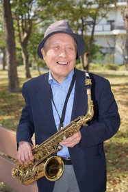 愛用のサックスを手に、教え子たちとの思い出を語る日下雄介さん＝神戸市中央区港島中町６（撮影・風斗雅博）