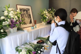 殺害された小尻知博記者を悼み、祭壇の前で手を合わせる人たち＝３日午前、西宮市与古道町、朝日新聞阪神支局（撮影・吉田敦史）