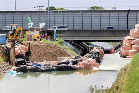 天神川の堤防が決壊し、復旧作業が続けられている＝８日午前１０時３１分、伊丹市荒牧６