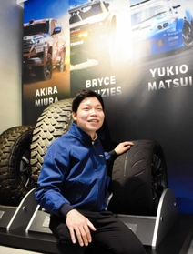国際レースやラリーなどで使用されたタイヤに触れる宮園拓真さん＝伊丹市藤ノ木２、トーヨータイヤ本社