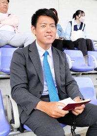 メモ帳を手にネット裏から選手の動きをチェックする巨人スカウトの桜井俊貴さん＝京都市内