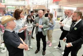 震災の再開発地区で伊東正和さん（左）から話を聞くウクライナの視察団＝２２日午後、神戸市長田区久保町６