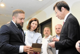 ウクライナ南部ミコライウ市のセルヒー・コレニエフ副市長（左端）から、被害の実相を伝えるため、ロシア軍が放ったミサイルの破片を手渡された久元喜造神戸市長＝２２日午前、神戸市役所