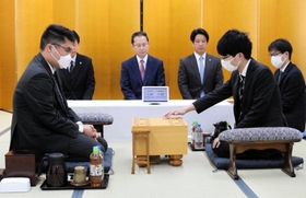 加古川青流戦の開幕局で初手を指す藤本渚四段（右）。左は高田明浩四段＝２７日午前、加古川市加古川町溝之口