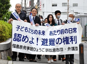 横断幕を掲げて神戸地裁へ向かう原告団ら＝３０日午後、神戸市中央区橘通２