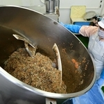 食材をかき混ぜる工程。周囲にふわりと磯の香りが漂う＝神戸市西区高塚台５、澤田食品（撮影・中西幸大）