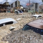 天神川の堤防が決壊し、土砂に埋もれた車＝８日午前、伊丹市荒牧６（撮影・吉田敦史）