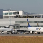 現在の神戸空港旅客ターミナルと駐機スポット。神戸市は空港の敷地を西側に広げ、国際チャーター便などを受け入れるサブターミナルを整備する＝２０２２年１２月、神戸市中央区