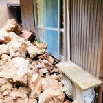 山腹が崩れ、民家に押し寄せた岩石＝８日、豊岡市出石町片間（豊岡市提供）