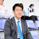 メモ帳を手にネット裏から選手の動きをチェックする巨人スカウトの桜井俊貴さん＝京都市内