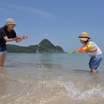 浜辺で水遊びをする親子＝１７日午前、豊岡市竹野町竹野（撮影・斎藤雅志）