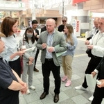 震災の再開発地区で伊東正和さん（左）から話を聞くウクライナの視察団＝２２日午後、神戸市長田区久保町６