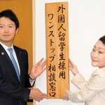 ワンストップ相談窓口の看板を掲示する斎藤元彦知事（左）と中井伊都子・大学コンソーシアムひょうご神戸理事長＝神戸市中央区脇浜町１