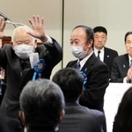集会で、車いすから立ち上がり、支援者らに手を振る有本明弘さん＝東京都千代田区