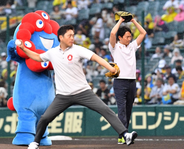 ファーストピッチセレモニーを行う吉村洋文大阪府知事（手前）と斎藤元彦兵庫県知事＝１４日午後、西宮市の甲子園球場