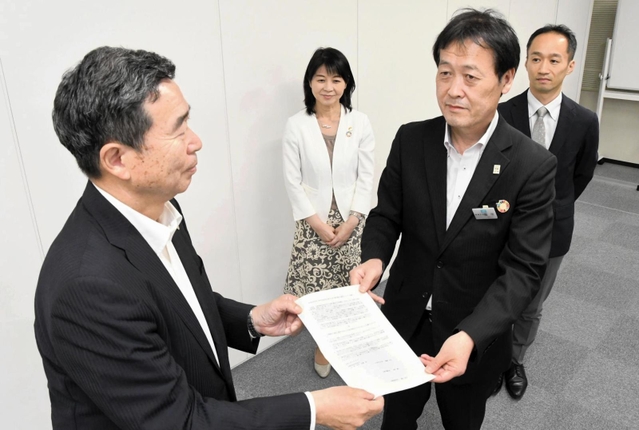 兵庫県経営者協会の成松郁廣会長（左）に要望書を手渡す稲次一彦教育次長＝神戸市中央区京町