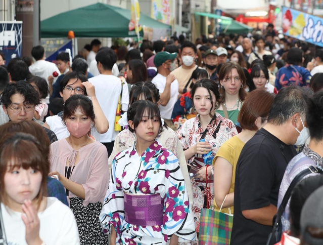 露店が並ぶ通りを浴衣姿でそぞろ歩く人たち＝２４日夕、姫路市西二階町（撮影・辰巳直之）
