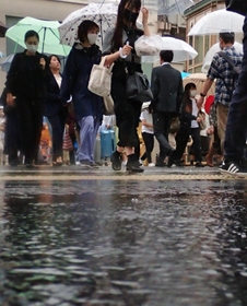 激しい雨の中を歩く人たち＝２日午前、神戸市央区元町通１（撮影・斎藤雅志）