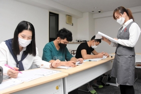 日本語能力試験の教材で勉強するベトナム人の男女。いずれも今春から神戸市内の介護施設で働き、週に１度は社会福祉法人職員から日本語の指導を受けている＝６月１日、神戸市兵庫区大開通８