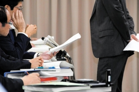資料を手に市教委の関係者に迫る被害男性の父＝１２日午後、神戸市内