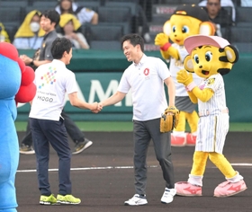 ファーストピッチセレモニーを終え、兵庫県の斎藤元彦知事（左）と握手を交わす大阪府の吉村洋文知事＝１４日午後、西宮市の甲子園球場（撮影・高部洋祐）