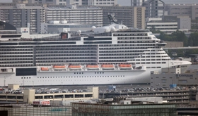 神戸のビル群に溶け込む「ＭＳＣベリッシマ」＝１３日、神戸市灘区の灘丸山公園から