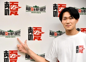 大会のロゴを指さす大武優斗さん＝東京都江東区、武蔵野大有明キャンパス