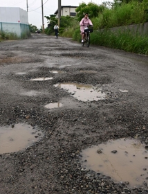 穴だらけの県道長坂垂水線＝神戸市垂水区多聞町と同市西区伊川谷町長坂の境界付近（撮影・中西幸大）