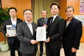 谷公一防災担当相（左から２人目）に要望書を手渡す藤本真一実行委員長（同４人目）＝東京都千代田区