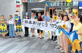 横断幕を掲げ、戦争終結への願いを訴えたウクライナ避難民ら＝神戸市中央区加納町４、サンキタ広場