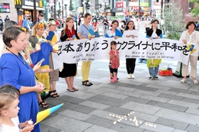 横断幕を掲げ、戦争終結への願いを訴えたウクライナ避難民ら＝神戸市中央区加納町４、サンキタ広場