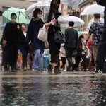 激しい雨の中を歩く人たち＝２日午前、神戸市央区元町通１（撮影・斎藤雅志）
