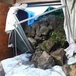 民家裏の石垣が崩れ、窓ガラスを割って寝室に流れ込んだ＝２日午後０時２８分、姫路市的形町的形（撮影・辰巳直之）