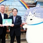 勝野哲也社長（中央）から絵本を受け取る小山光一校長＝神戸市須磨区堀池町１