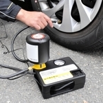 住友ゴム工業のパンク修理キット。自動車のシガーソケットにつないでコンプレッサーのスイッチを入れると、自動で修理剤と空気がタイヤに注入される＝伊丹市瑞穂町２
