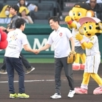 ファーストピッチセレモニーを終え、兵庫県の斎藤元彦知事（左）と握手を交わす大阪府の吉村洋文知事＝１４日午後、西宮市の甲子園球場（撮影・高部洋祐）