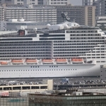 神戸のビル群に溶け込む「ＭＳＣベリッシマ」＝１３日、神戸市灘区の灘丸山公園から