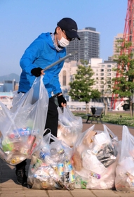 大量の空き缶や食品の容器を回収する難波久芳さん＝５月下旬、神戸市中央区波止場町