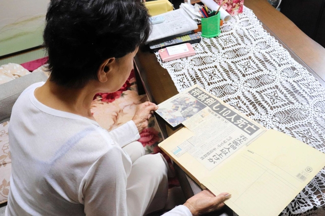 事故発生を伝える新聞を見ながら当時の体験を語った女性＝神戸市西区