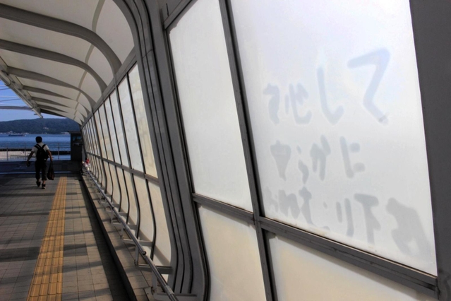「安らかにおねむり下さい」。歩道橋の外壁に残る文字の跡。事故直後、粘着テープでしたためられたメッセージだ＝明石市大蔵海岸通１