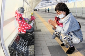 草替律子さんの名が刻まれた慰霊碑に手を合わせる長女の寺元廷美さん＝明石市大蔵海岸通１