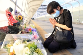 「想の像」の前に花束を供え、手を合わせる山本直美さん。７歳で亡くなった佐藤隆之助君が０歳だったときの保育園の担任だった＝２１日午後、明石市大蔵海岸通１（撮影・吉田敦史）