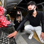 身をていして命を救ってくれた草替律子さんの名前が刻まれる慰霊碑を見つめる山下翔馬さん（右）と母の佳奈さん＝１４日夜、明石市大蔵海岸通１、朝霧歩道橋（撮影・秋山亮太）