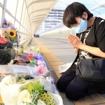 「想の像」の前に花束を供え、手を合わせる山本直美さん。７歳で亡くなった佐藤隆之助君が０歳だったときの保育園の担任だった＝２１日午後、明石市大蔵海岸通１（撮影・吉田敦史）