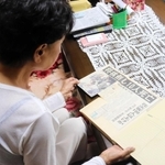 事故発生を伝える新聞を見ながら当時の体験を語った女性＝神戸市西区