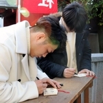 ２０２０年の誓いを絵馬にしたためる阿部一二三（左）と妹の詩＝神戸市兵庫区和田宮通３、三石神社