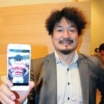「ＯＮＥ　ＴＥＡＭ」とボディーペイントされた写真を手に笑顔を見せる森山漠さん＝大阪市内