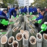 神港学園の部員とボランティア活動に取り組む北原光広前監督（右から２人目）と長男直也監督（左から２人目）＝１６日午後、神戸市中央区の東遊園地